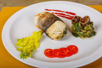 Involtino di pesce spada ripieno di verdure e mozzarella con contorno di verdure e pomodori e un...