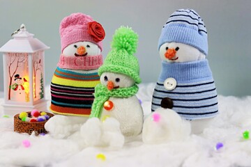 Three snowmen made with their own hands from socks and cotton wool. The New Year mood inspires us to make winter characters and landscapes.