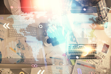 Double exposure of man and woman working together and world map hologram drawing. international network concept. Computer background. Top View.
