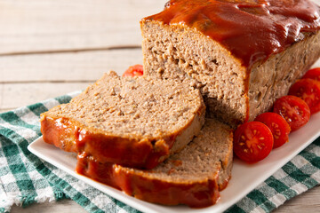 Traditional American meatloaf with ketchup on rustic wooden table	