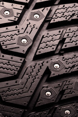 winter studded tire tread close-up. safe winter tires pattern background spike and safety vertical photo