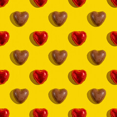 Seamless pattern with heart shaped chocolate candies on yellow background.