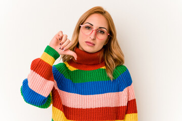 Young caucasian woman wearing a sweater with stripes isolated on white background showing a dislike gesture, thumbs down. Disagreement concept.