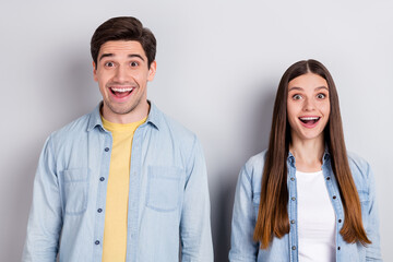 Photo of funny impressed brother sister dressed denim shirts smiling open mouth isolated grey color background