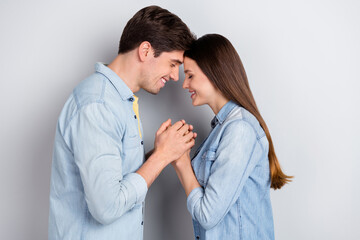 Photo of sweet cute guy lady dressed denim shirts touching heads closed eyes holding arms isolated grey color background