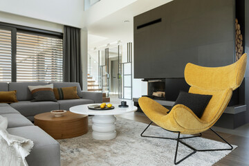 Modern living room interior design with corner beige sofa,  rounded coffee tables, mustard armchair, fireplace and accessories.  Template. .