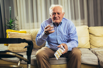 Senior man taking pills at home