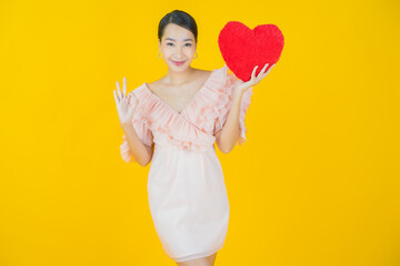 Portrait beautiful young asian woman smile with heart pillow shape