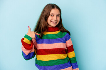 Little caucasian girl isolated on blue background person pointing by hand to a shirt copy space, proud and confident