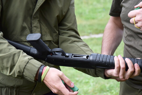 A young guy is trained in combat shooting from a shotgun.