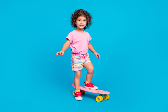 Full length body size view of attractive cheery girl riding skate having fun isolated over bright blue color background
