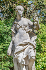 Ancient decayed statue of a sensual Renaissance Era woman in the central city park of Potsdam, a German town of statues and sculptures, Germany