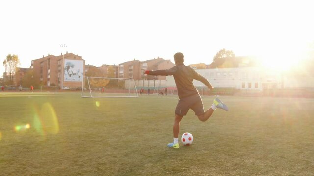 An African American woman training on the football field and fulfills feints with the ball in motion. Slow motion