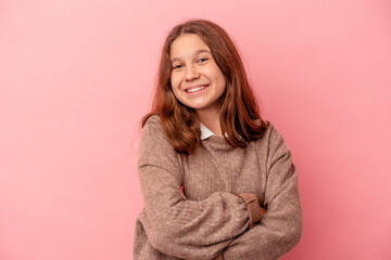 Fototapeta premium Little caucasian girl isolated on pink background who feels confident, crossing arms with determination.