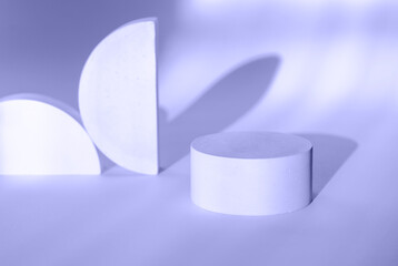 Round plaster podium for advertising cosmetics on the background in Very Peri color with beautiful shadows