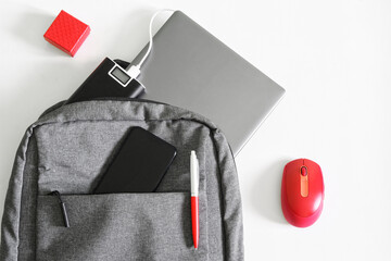 Laptop, smartphone, mobile, power bank, mouse and gray backpack or bag on white background....