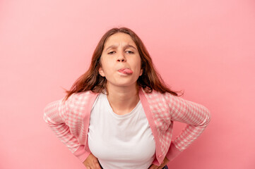 Little caucasian girl isolated on pink background funny and friendly sticking out tongue.