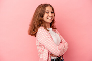 Fototapeta premium Little caucasian girl isolated on pink background who feels confident, crossing arms with determination.