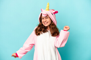 Little caucasian girl wearing a unicorn pajama isolated on pink background