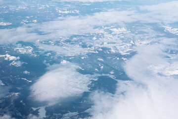 Snowy mountains and clouds view from above . Aerial view of mountainous area in the winter 