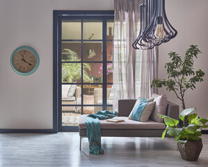 Sofa, lamp, pillow, clock and garden view interior room, vase of plant, parquet floor.