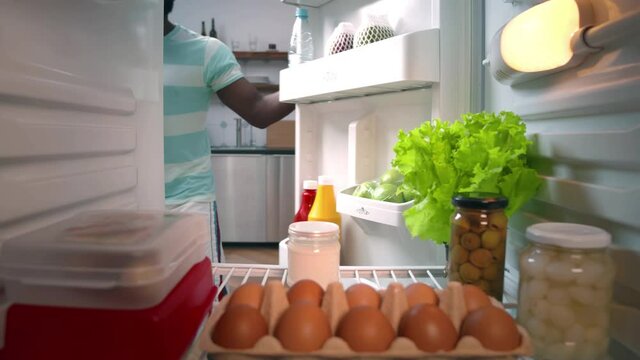 African-American Ethnicity Man Opening Door Of Fridge To Get Milk And Closing Door. Realtime