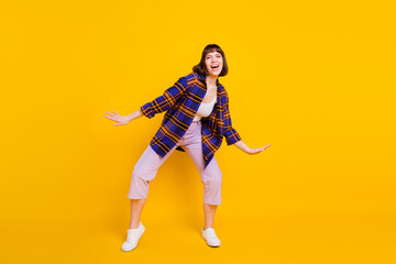 Fototapeta na wymiar Full length body size view of attractive cheerful childish girl dancing having fun isolated over bright yellow color background
