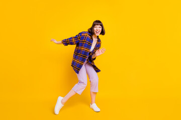 Fototapeta na wymiar Full length body size view of attractive cheerful ecstatic girl dancing having fun fooling isolated over bright yellow color background