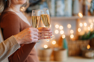 hands couple in love with glasses of champagne in christmas's kitchen. romantic.