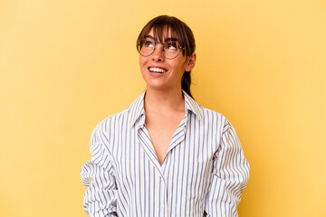 Young Argentinian woman isolated on yellow background relaxed and happy laughing, neck stretched showing teeth.