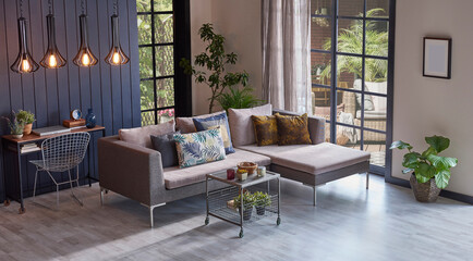 Modern grey sofa in front of the garden view and wooden background wall, lamp vase of plant and middle table, home design.