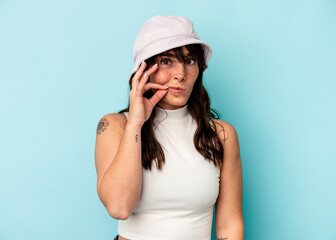Fototapeta premium Young Argentinian woman isolated on blue background with fingers on lips keeping a secret.