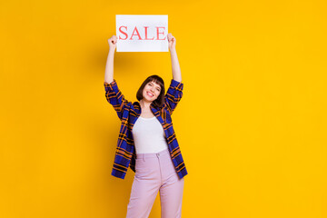 Portrait of attractive cheerful girl holding in hands sale word poster board new novelty isolated...