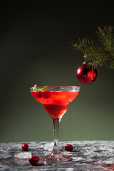 Drink with cranberries and alcohol in a conical glass on a concrete surface
