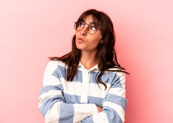Young Argentinian woman isolated on pink background dreaming of achieving goals and purposes