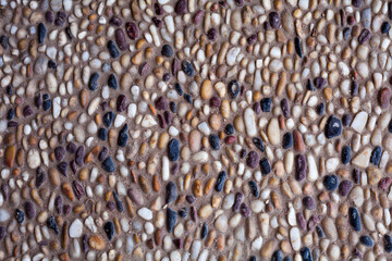 background made of a closeup of a wall with pebbles, The texture of natural stones, a path of...