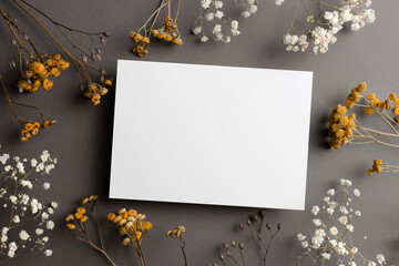 Wedding invitation card mockup with dry flowers twigs on grey