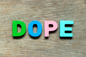 Color alphabet letter in word dope on wood background