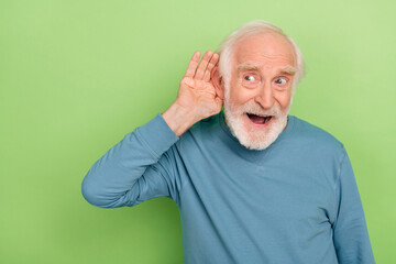 Photo of funky aged beard man listen wear blue sweater isolated on green color background