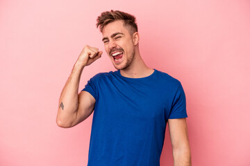 Young caucasian man isolated on pink background celebrating a victory, passion and enthusiasm, happy expression.