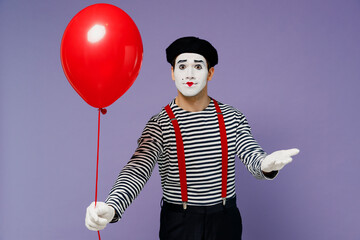 Vivid happy young mime man with white face mask in striped shirt beret hold give present colorful...