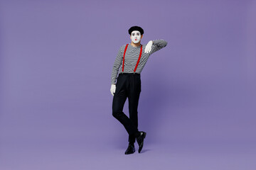 Full size body length confident young mime man with white face mask wears striped shirt beret look camera lean on something invisible isolated on plain pastel light violet background studio portrait.