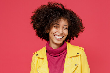 Obraz na płótnie Canvas Laughing bright happy fun young curly black latin woman 20s years old wears yellow jacket keep eyes closed smiling isolated on plain red background studio portrait. People emotions lifestyle concept.
