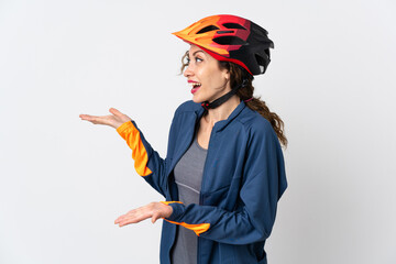 Young cyclist woman isolated on white background with surprise expression while looking side