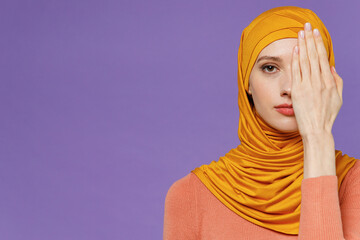 Close up upset severe young arabian asian muslim woman in abaya hijab yellow clothes look camera...