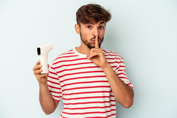 Young mixed race man holding thermometer isolated on blue background keeping a secret or asking for silence.