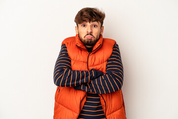 Young mixed race man isolated on grey background shrugs shoulders and open eyes confused.