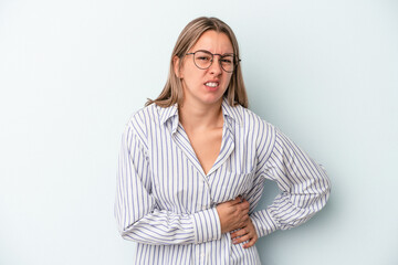 Young caucasian woman isolated on blue background having a liver pain, stomach ache.