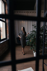 young woman in a black dress with polka dots and black classic shoes