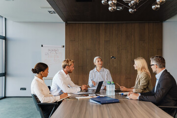 Multiracial men and women discussing project during meeting